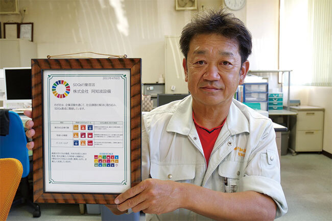 SDGsの行動宣言書を持つ阿知波久晴代表取締役
