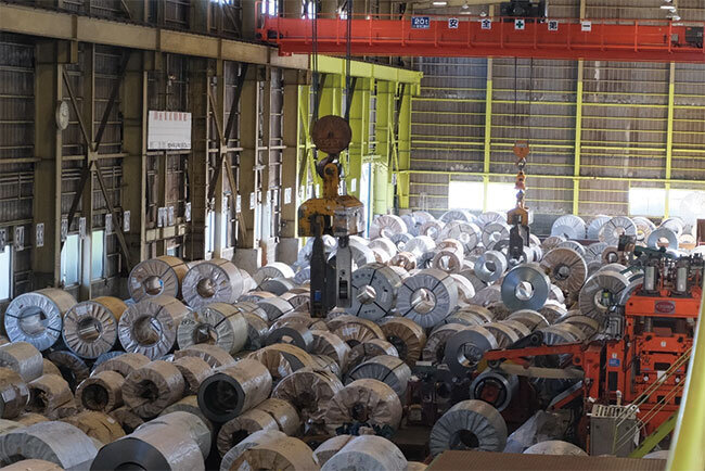 工場内にはさまざまなタイプのコイル状の鋼板が保管されている
