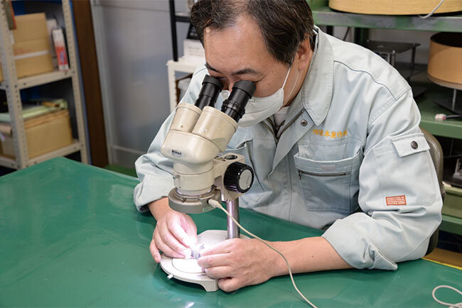 加工が完了した歯車の検品は専用機械による検査と顕微鏡による目視で行われている
