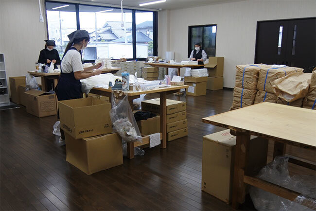 吉田織物の作業場。協力工場から届いた商品を個別に包装して出荷する