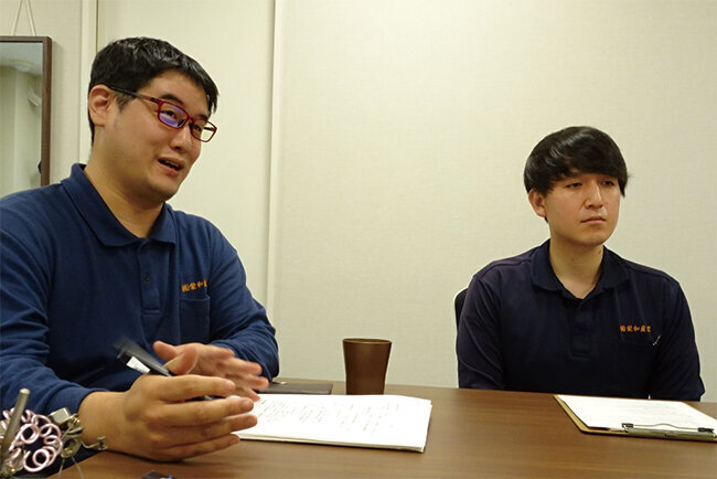 企画部の伊田一平主任（右）とホームページの更新担当の横田博之さん（左）