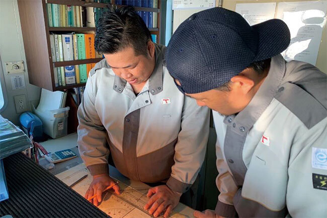タンカー船内で海図を確認しながら任務に従事する大東汽船の従業員