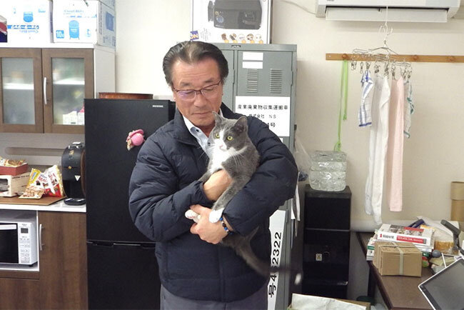 事務所のマスコット猫を抱く北澤泰美社長