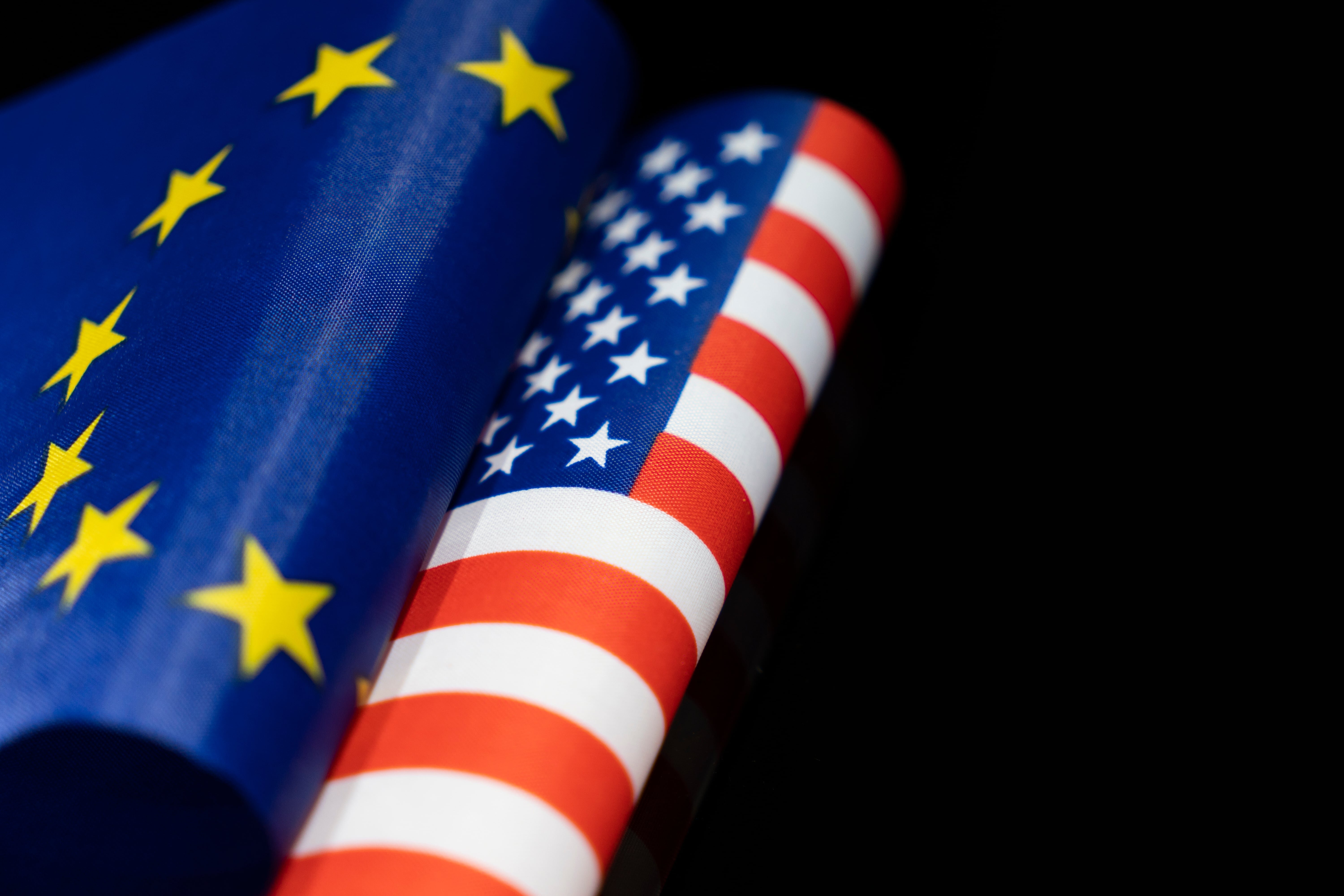 ヨーロッパ連合(EU)とアメリカ合衆国の国旗が並んでいる。欧米におけるCSRの考え方や文化的背景を象徴するイメージ。